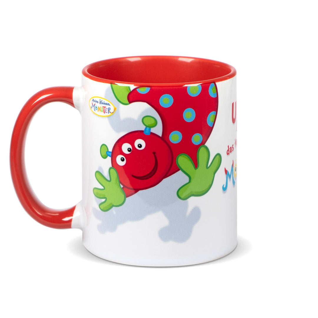 Keramiktasse mit rotem Henkel und rotem Innenrand, bedruckt mit dem roten Monster „Upsi“ mit grünen Händen und gepunktetem Körper.