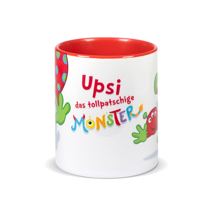 Weiße Keramiktasse mit rotem Innenrand und der Aufschrift „Upsi das tollpatschige Monster“ in bunter, verspielter Schrift.