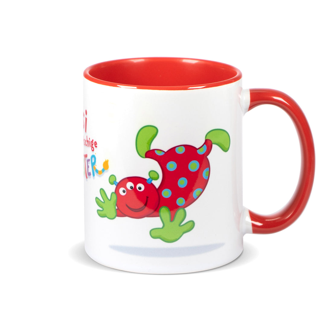 Keramiktasse mit rotem Henkel und rotem Innenrand, Motiv zeigt das rote Monster „Upsi“ vollständig von vorne.